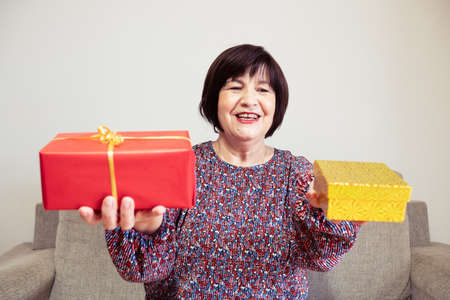 A senior mum holding two presents on her hands