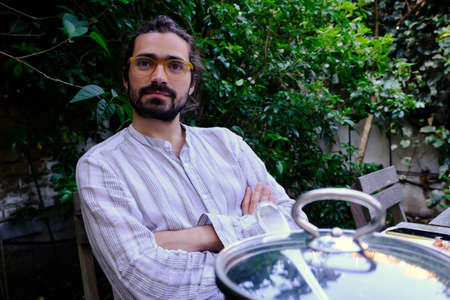 Mid man with arms crossed and a pot sitting after lunch