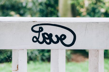 Love lettering on a white wooden benchの写真素材