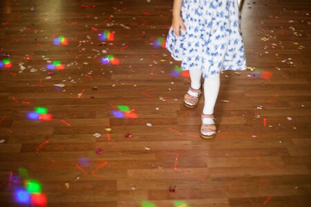Colorful confetti on the floor and dancing girlの写真素材