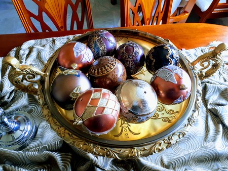 A photo showing an oriental style home furniture consisting of a vase that is filled with decorative glass balls. The vase is sitting on a dining table.の写真素材