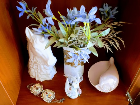 A photo showing some home decoration furniture in white, consisting of two vases with artificial plants on it, an ashtray, and some accessories.の写真素材