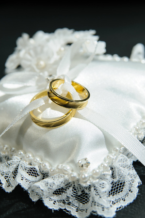 Pair of rings on white cushion. The rings represent the union of a couple.の写真素材