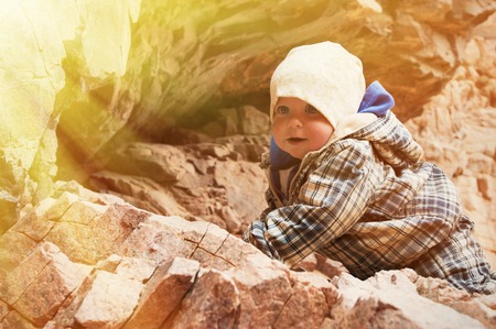 Baby climbing on a rockの写真素材