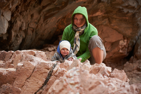 Mom and little son sitting on the rockの写真素材