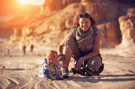 Mom and his little son are walking in the canyonの写真素材