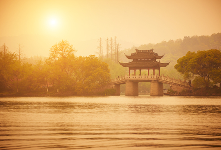 Traditional Style Pavilion And Bridge at XiHu Lake at sunset, Hangzhou, Chinaの写真素材