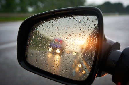Truck in a rear view mirror at sunsetの写真素材
