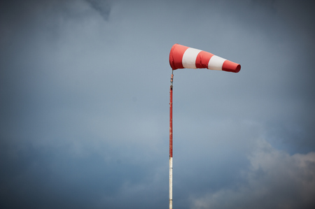 Windsock blown by the wind with overcast skyの写真素材