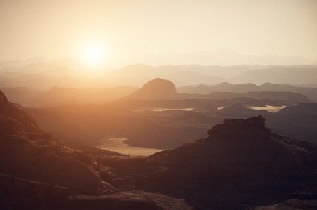 Valley in the desert with mountains at sunsetの写真素材