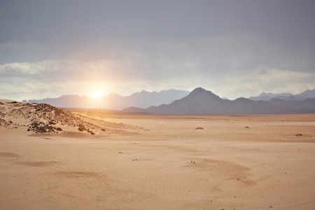 Valley in the desert with mountains at sunsetの写真素材