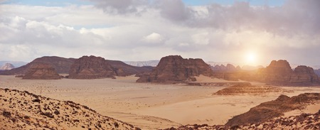 Valley in the desert with mountains at sunsetの写真素材