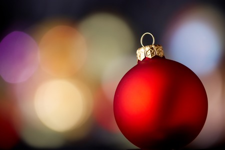 Red ball over blurred lights background. Christmas and New Year Decoration.の写真素材