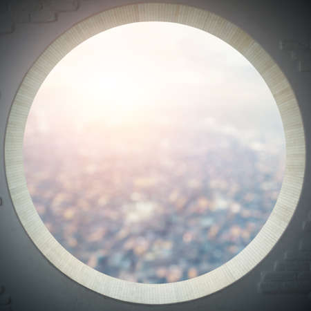 empty round window with aerial view of a city at sunsetの写真素材