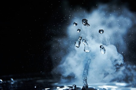 Boiling water splash with steam on black background closeupの写真素材