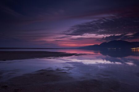 Sunset over a beach during low tideの写真素材