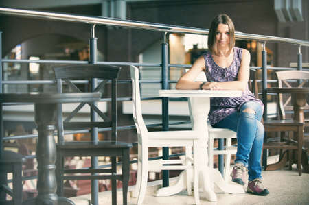 happy young woman sitting in cafeの写真素材
