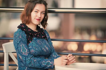 portrait of a smiling young woman sitting in the cafeの写真素材