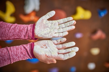 hands with liquid bouldering chalk over blured climbing wall backgroundの写真素材