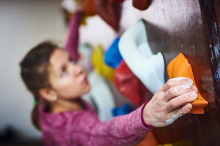 sporty woman in boulder climbing hall. focus on a handの写真素材