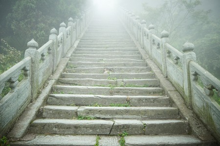 A stone stairs in the fog going into lightの写真素材