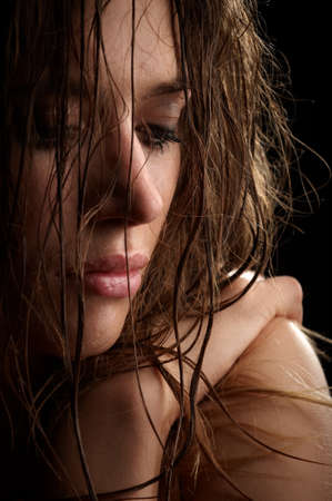 beautiful long hair brunette woman portrait, wet face, studio shotの写真素材