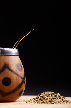 Traditional South American yerba mate tea in the calabash circle and Bombilla. Black backgroundの写真素材