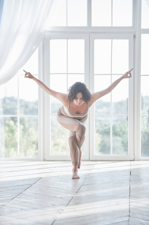 Beautiful young woman practices yoga asana Garudasana - Eagle pose at the yoga studioの写真素材