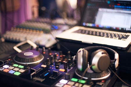 soundmixer sound control panel with computer and headphones in the foregroundの写真素材