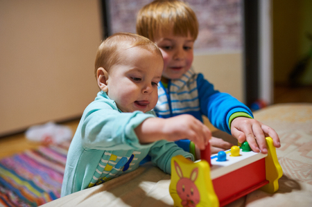 cute little boys playing with toys by the homeの写真素材