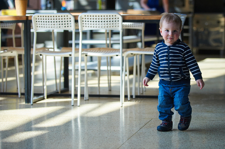 Cute toddler walking in the shopping center.の写真素材
