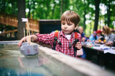 Outdoors portrait of cute preschool boy playing homemade ship in the park.の写真素材