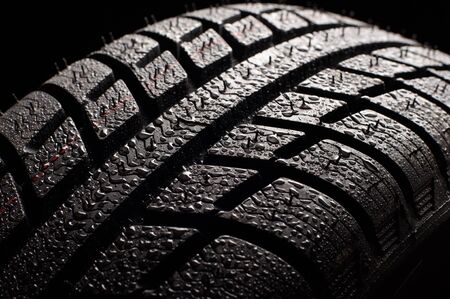 Brand new winter tire pattern on black background.