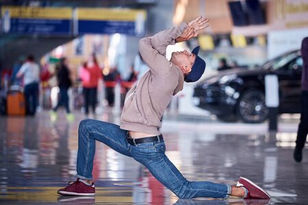 Young man practices yoga asana indoors in the public place.の写真素材