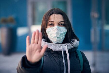 Woman in mask on street because epidemic of coronavirus in city. Protection against virus and...