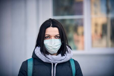 Woman in mask on street because epidemic of coronavirus in city. Protection against virus and...