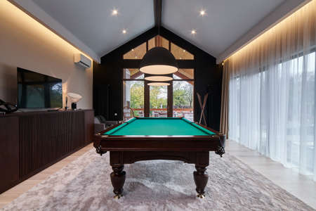 modern billiard room with a beautiful table and large windows. Nobody.のeditorial素材