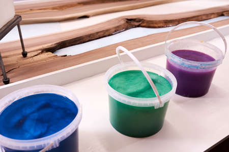 Process making of a craft resin and wood table. Liquid epoxy is poured into a mold with wooden blanks. closeupの写真素材