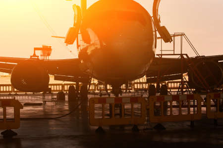 plane in a hangar during service at sunset against bright sunlight.の写真素材