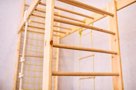 wooden wall bars ladder in big empty gym room of school no people
