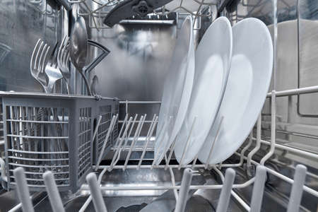 Interior of dishwasher machine with clean dishes after washing.の写真素材