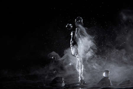 Boiling water splash with steam on black background closeup.の写真素材