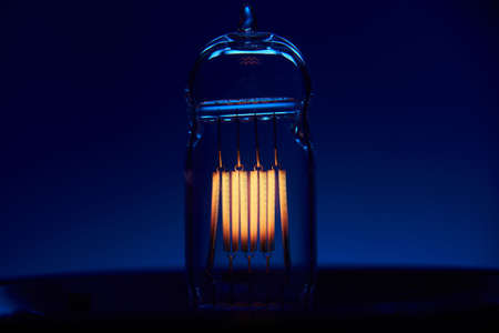 Electric vintage Edison light bulb with a spiral on a blue background. Retro style lamp.の写真素材