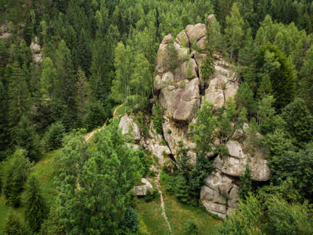 aerial top down view of a picturesque rock located among the spruce forest in the mountainsの写真素材