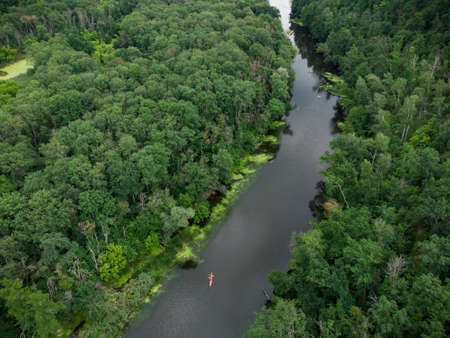aerial view of a large group of kayaks traveling on a forest river on a summer dayの写真素材