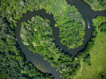 Aerial view over the river which is on the green forest. drone photoの写真素材