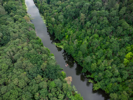 aerial view of a large group of kayaks traveling on a forest river on a summer dayの写真素材