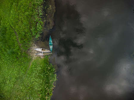 aerial top down view of old wooden boats near river bank on summer dayの写真素材