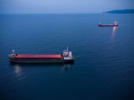 Large general cargo ship tanker bulk carrier, Top down aerial view at night.