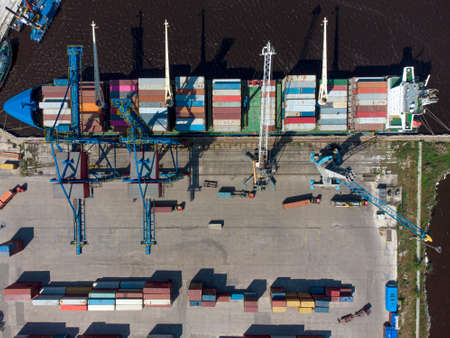 Aerial view of a container ship being loaded and unloaded at container terminal freight port